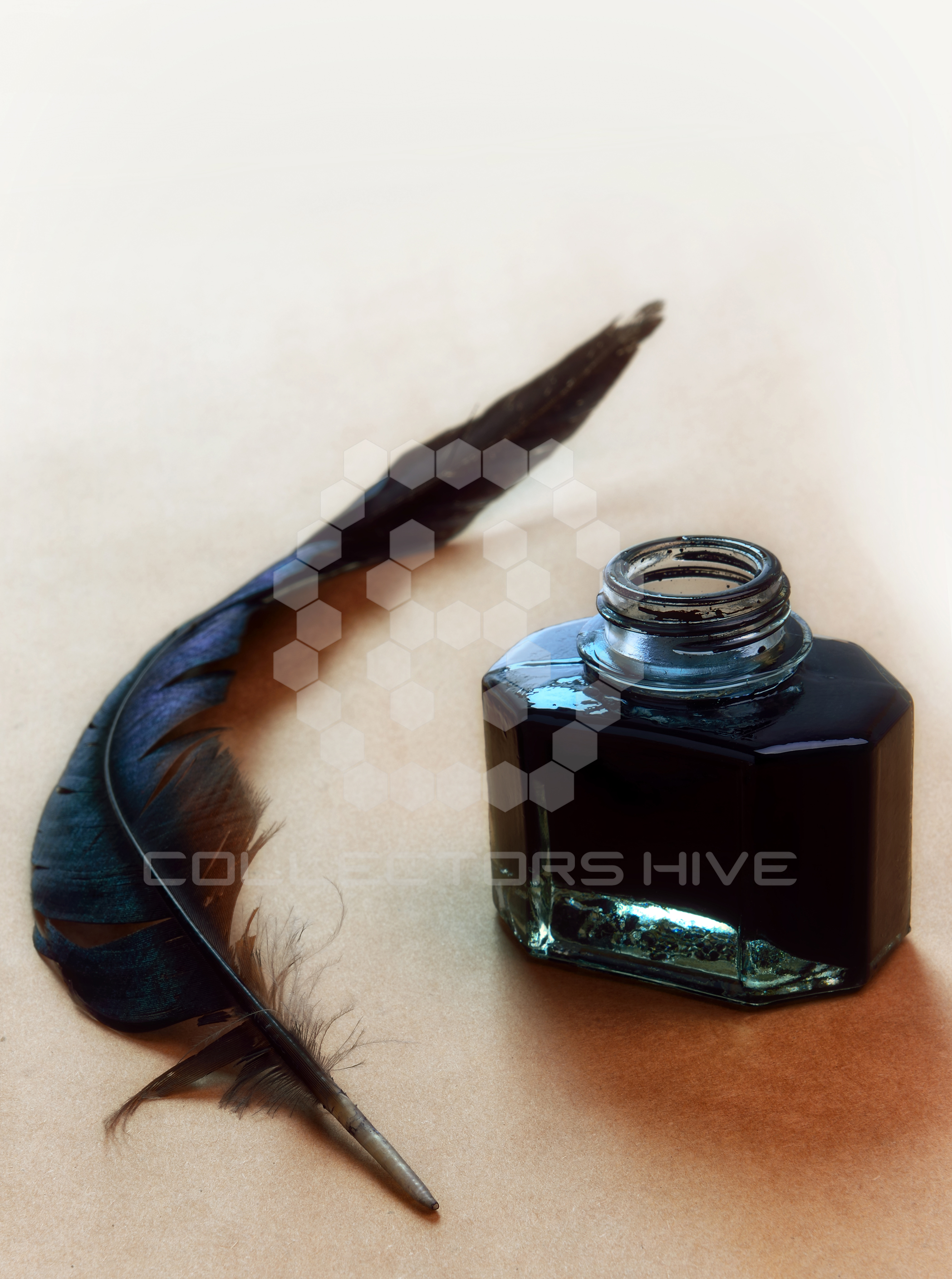Feather and ink bottle on brown paper background